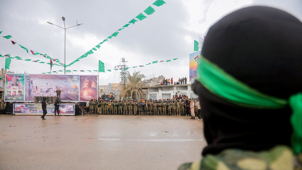 A coffin is paraded before a gathering that includes Hamas members.