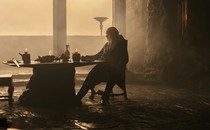 Matt Smith sitting at a table in a gloomy castle in "House of the Dragon"
