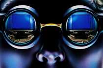 An illustration of a person wearing goggles that show the reflection of a computer screen in the lenses