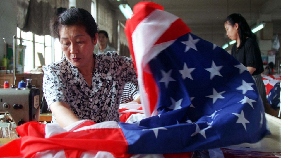 A seamstress sews together an American flag at a factory in Beijing.