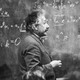 Albert Einstein in front of a chalkboard