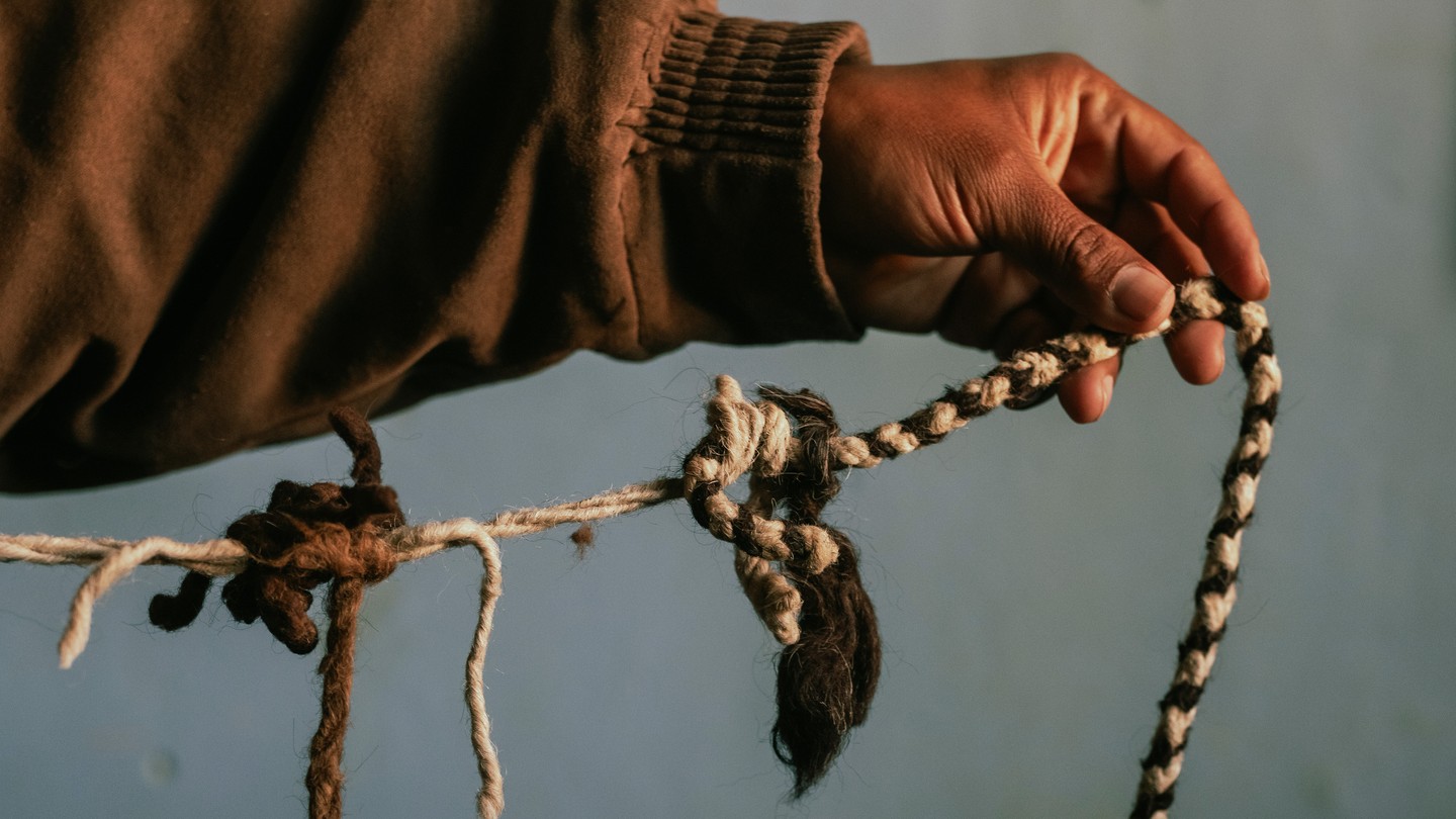 A man holds up a khipu