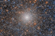 A dense cluster of many thousands of stars, brightening and becoming more dense toward the center of the image