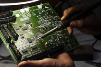 A technician works on a computer electronics component