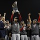The Boston Red Sox manager Alex Cora hoists the Commissioner's Trophy after defeating the Los Angeles Dodgers in Game Five of the 2018 World Series at Dodger Stadium.