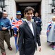 Rory Stewart emerges from TV studios in Westminster, London. A protester holding a sign reading "Stop Brexit" stands in the background.