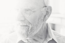 A black-and-white photo of a man with glasses and a beard