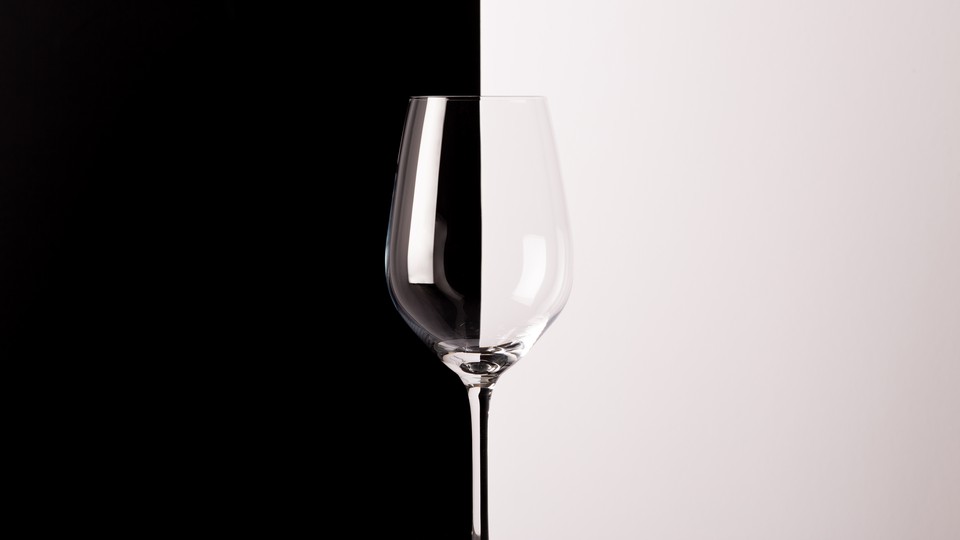 A photo of an empty wine glass in front of a black and white backdrop