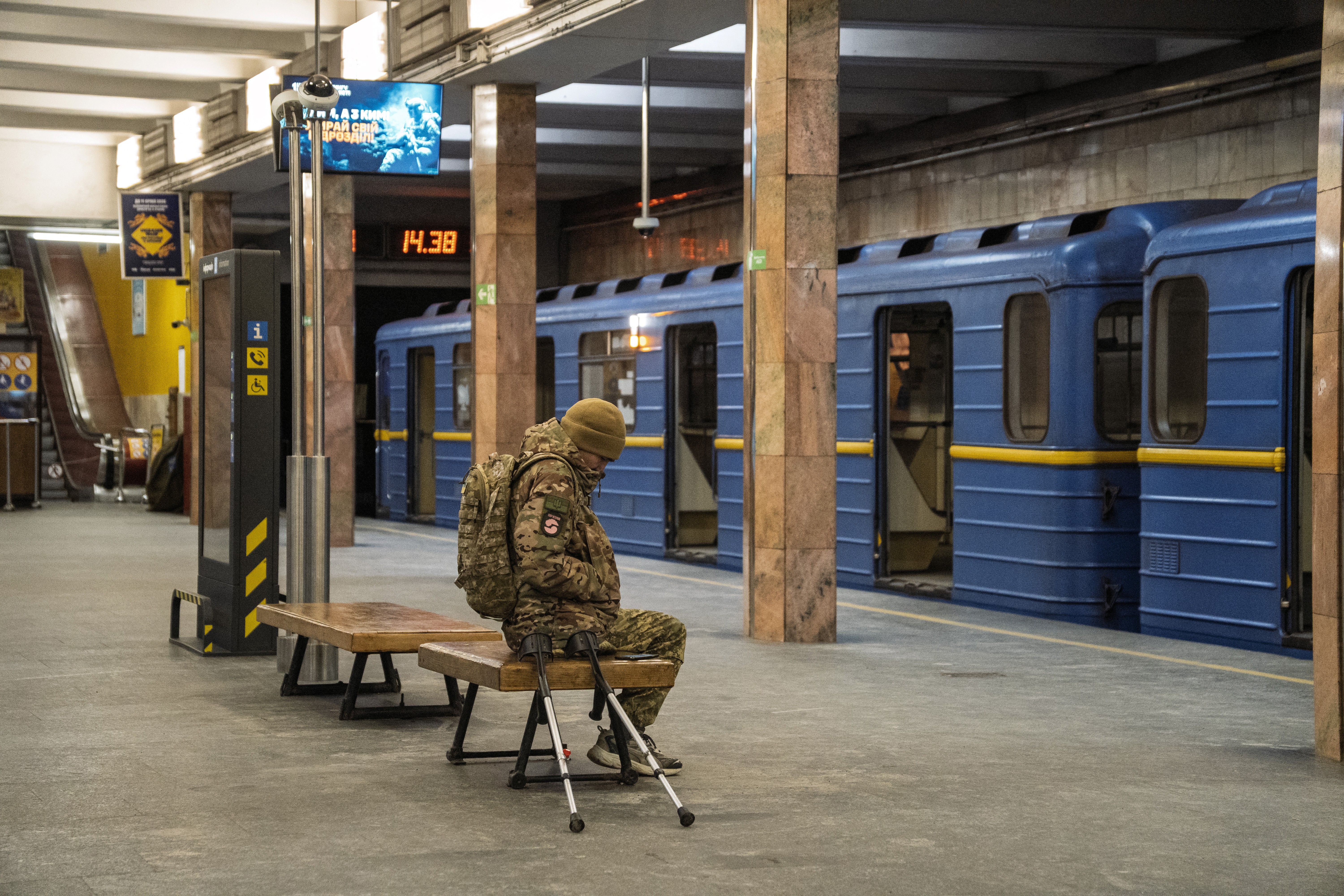 An army veteran sits on a bench at a metro station.