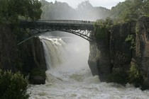 A swollen river under a bridge 