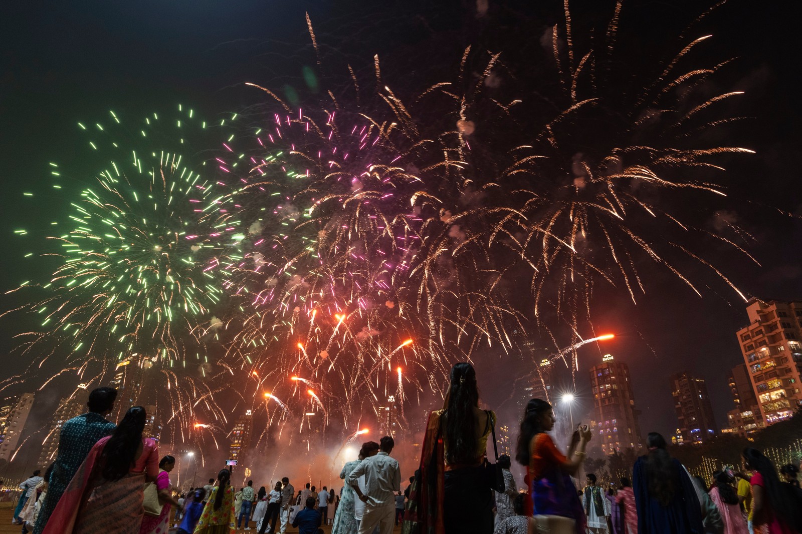 People look up at fireworks exploding overhead.