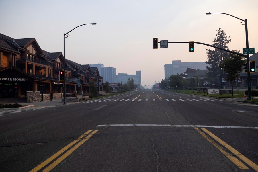 An empty street stands beneath a smoky sky.