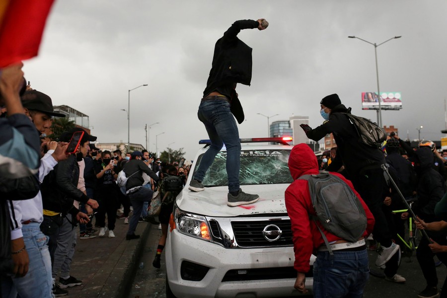 A demonstrator prepares to throw a stone at a police vehicle.