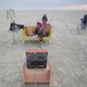 Two people sitting on a yellow sofa watching TV at Burning Man