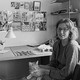 Black-and-white photo of artist Christina Ramberg seated in her studio with a cat in her lap.