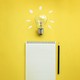 lightbulb, lined notepad, and pencil on yellow background