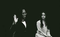 Kentaji Brown Jackson raises her right hand at her confirmation hearings while her daughter looks on