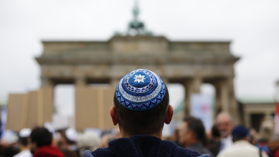 A man waits for the start of a demonstration against anti-Semitism in Berlin.