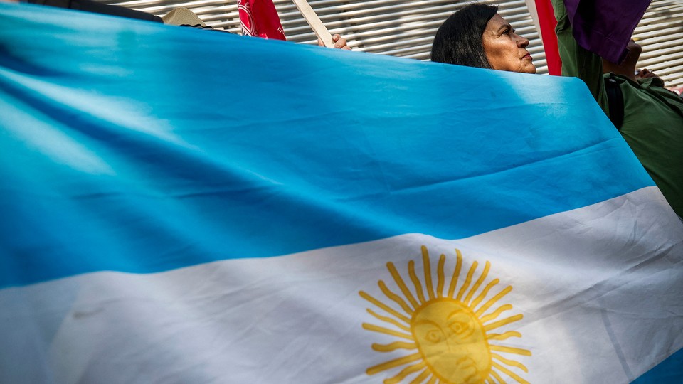 Photograph of a woman holding an Argentinian flag