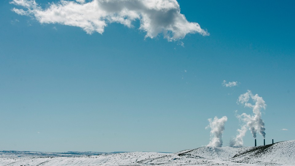 Steam billows from the PacifiCorp Hunter power plant in Castle Dale, Utah, on Feb. 6, 2019. It sits just behind a snowy hill.