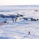 A photo of an ice camp with multiple tents and flags from many nations