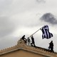 Greek parliament employees raise a mast after they replaced torn-off Greek flag with a new one atop the parliament in Athens Syntagma (Constitution) square on April 18, 2012.