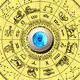 A blue artificial eyeball sits in the middle of a circular astrological chart.