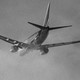 A black-and-white photo of a Southwest airplane taking off through low clouds