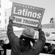 Two Trump supporters hold placards saying "Latinos for Trump" during a rally in Los Angeles.