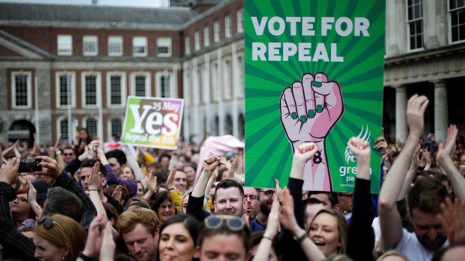 People hold signs celebrating the result of Ireland’s abortion referendum in Dublin