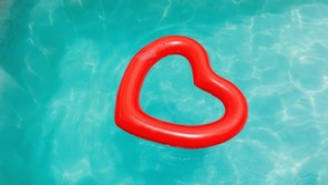 A red heart-shaped floaty in a blue pool