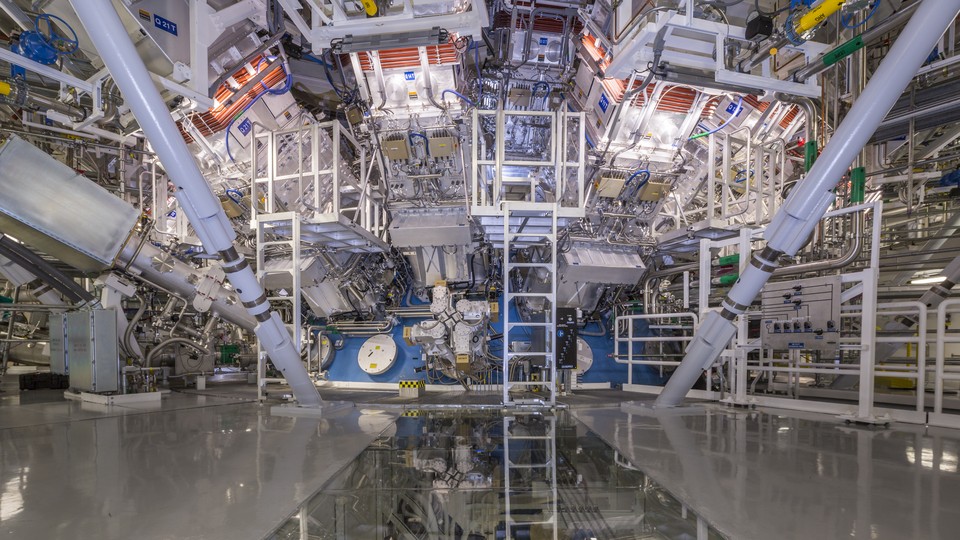 A photograph of the National Ignition Facility's target chamber, with ladders and pipes and tubes and other equipment