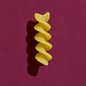 A piece of pasta on a purple background.