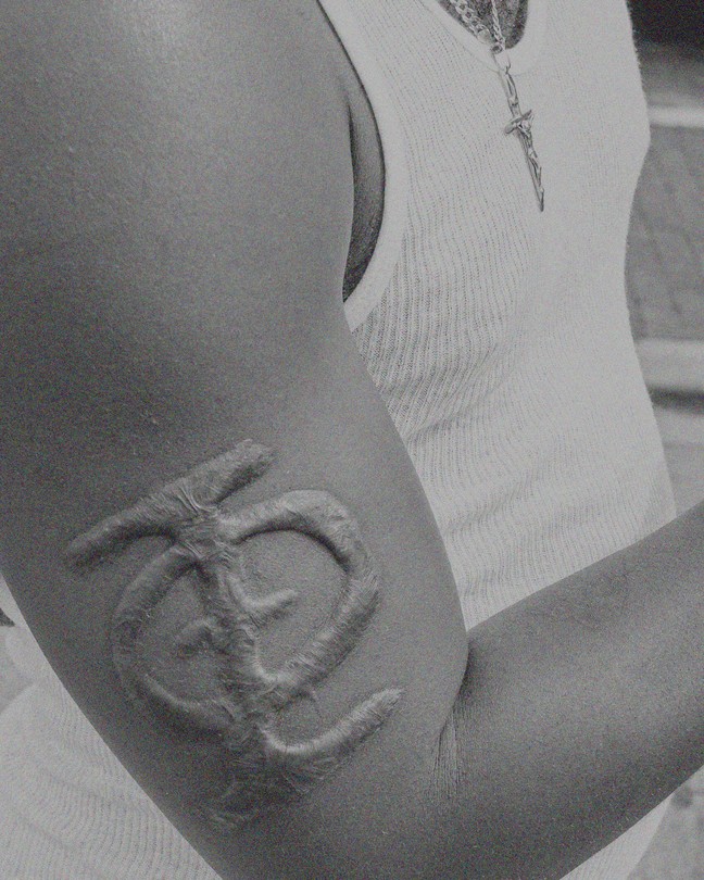 A man's arm with a branded fraternity symbol