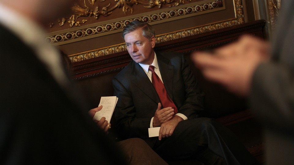 Photograph of Lindsey Graham sitting on a wooden bench.