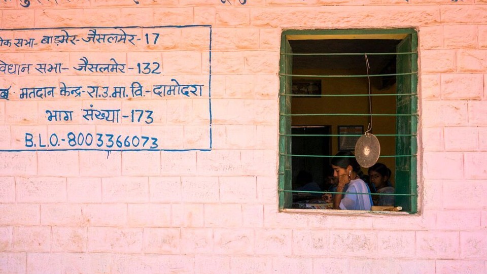 Students are seen studying through the window of a building. 