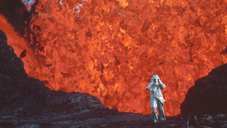 Katia Kraft wearing an aluminized suit standing near a lava burst at Krafla Voclano, Iceland