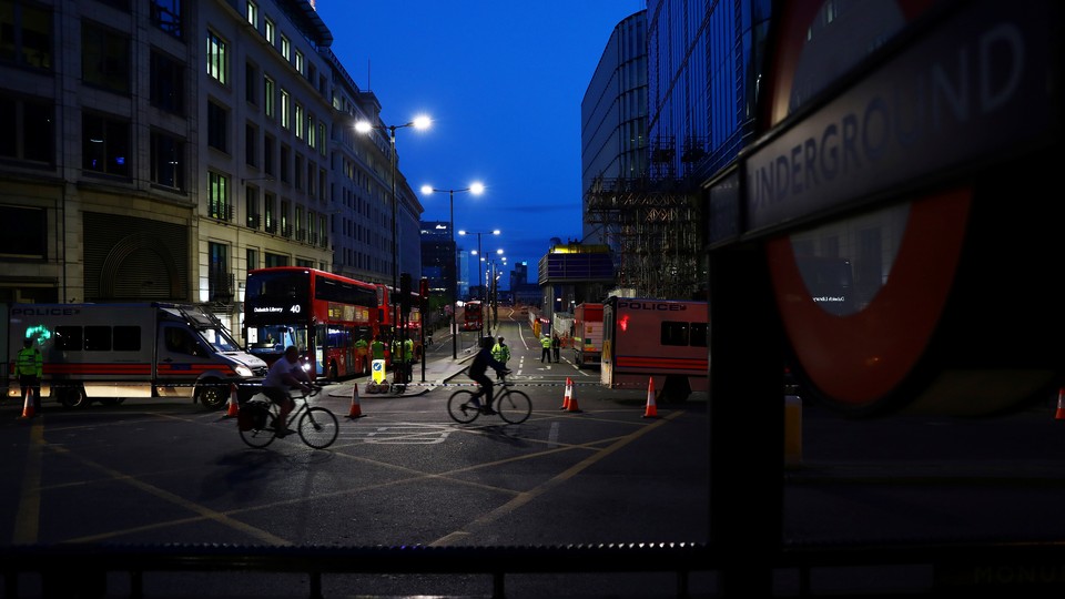 People cycle past a police cordon on the north side of London Bridge in London.