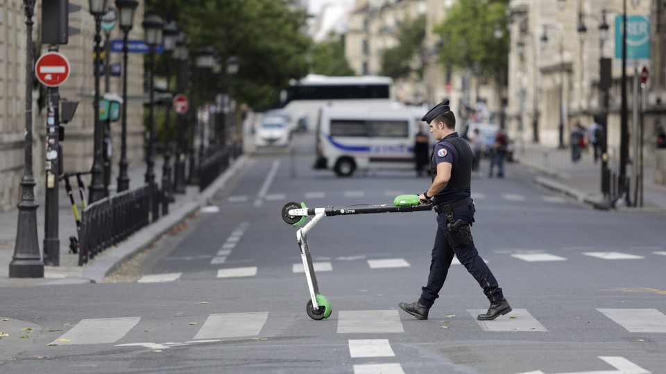 A police officer removes an electric scooter from the area around Notre-Dame cathedral in Paris.