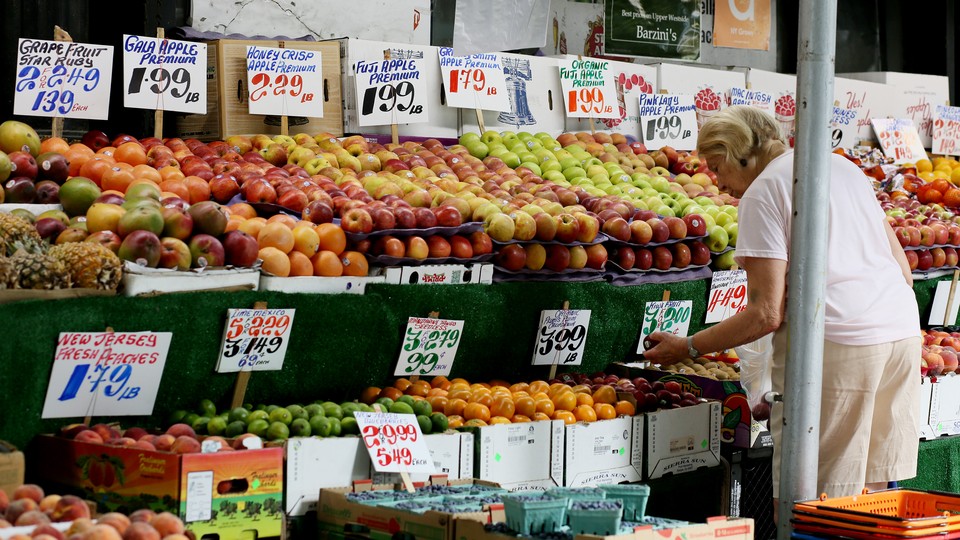 A woman picking fruit in a fresh market