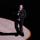 Smokey Robinson performing on a dance floor inside a bright spotlight