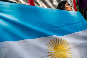 Photograph of a woman holding an Argentinian flag