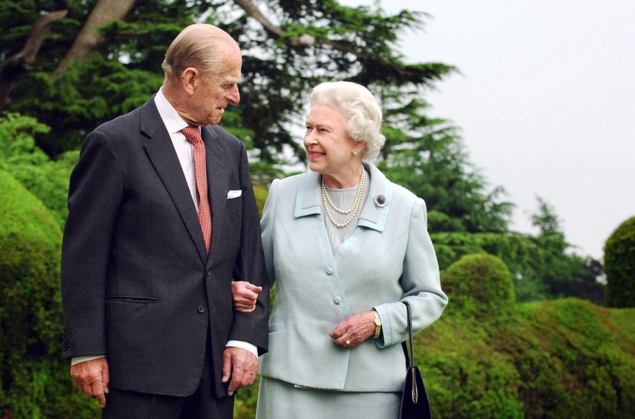 Queen Elizabeth walks with Prince Philip.