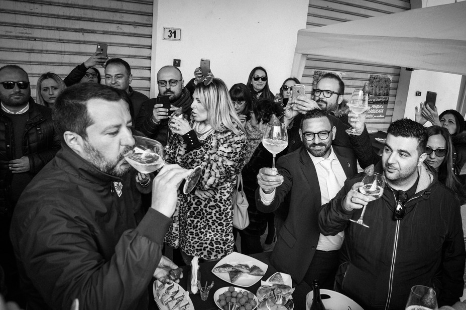 Matteo Salvini drinks a glass of wine at a party.