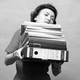 A black-and-white photo of tired woman holding a bunch of files