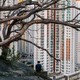 A man sits on a hill overlooking a residential estate in Hong Kong