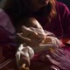 Photograph, taken through a window, of a baby in intensive care