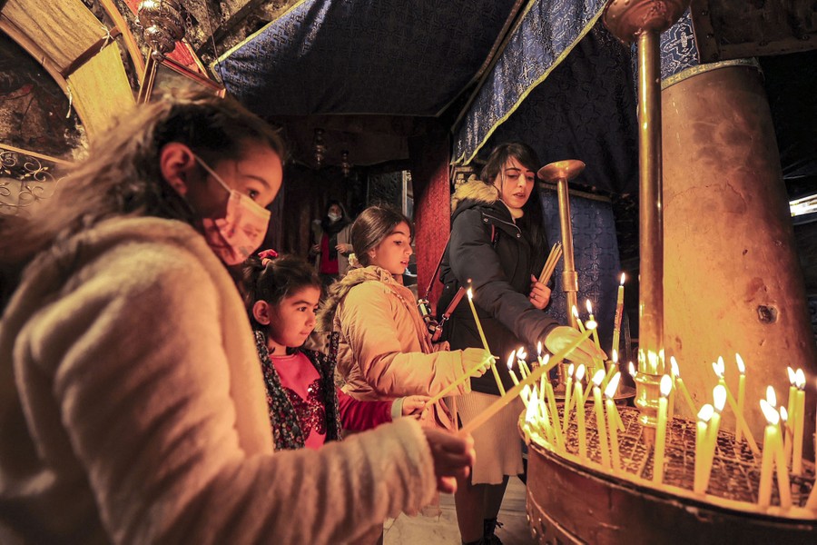 Children light candles in a small room.