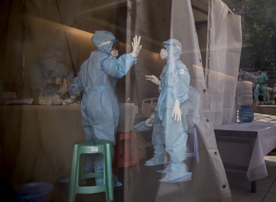 Health workers wearing protective gear stand inside a quarantine center.