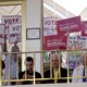 A photo of anti-abortion protesters holding up signs to the windows of a legislative assembly